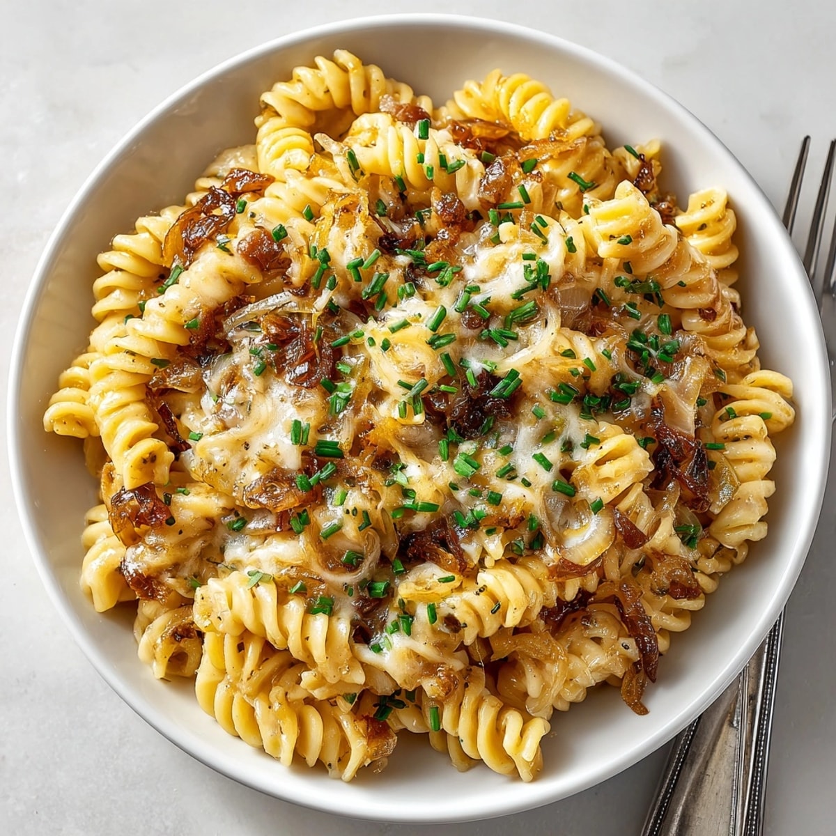 A steaming bowl of One-Pan French Onion Pasta showcases the rich, creamy cheese sauce beautifully.