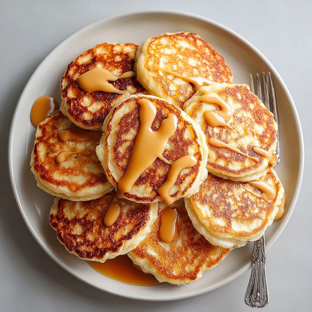 American-style protein pancakes topped with rich peanut butter syrup, served fresh for a nourishing morning meal.