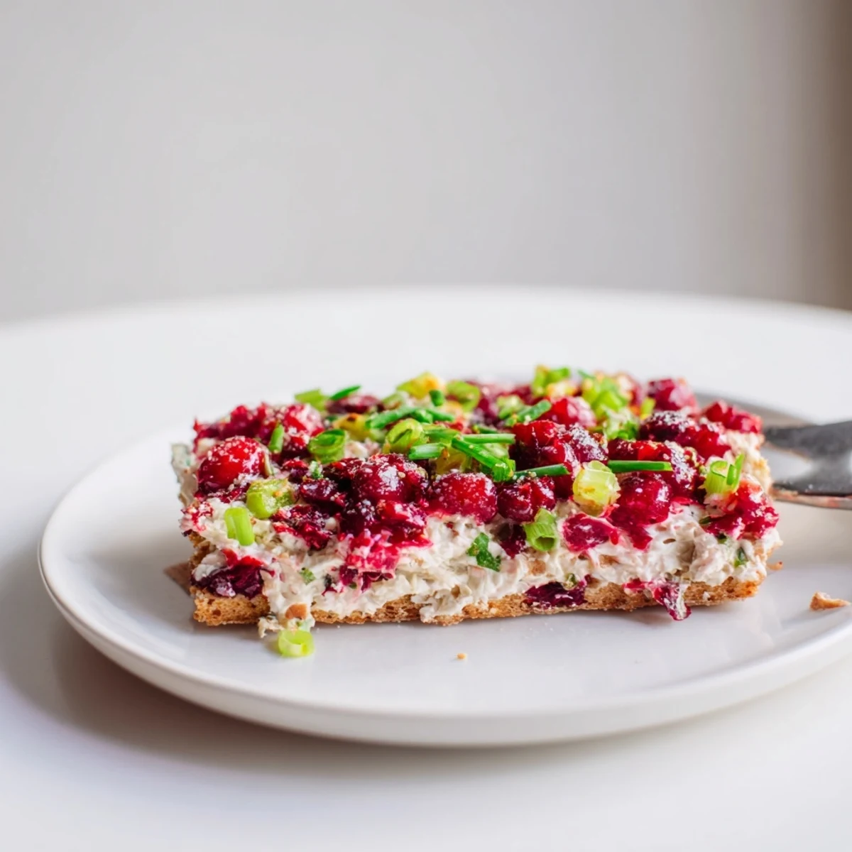 Creamy Spicy Ginger Cranberry Jalapeño Dip spread on crackers, bursting with flavor and zest.