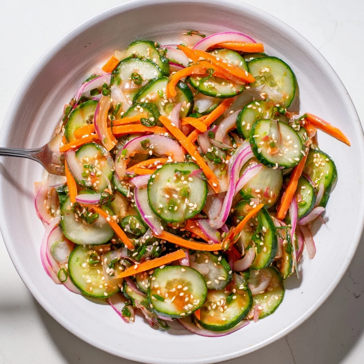 Refreshing cucumber salad remix with sesame oil and vibrant vegetables ready to serve.  