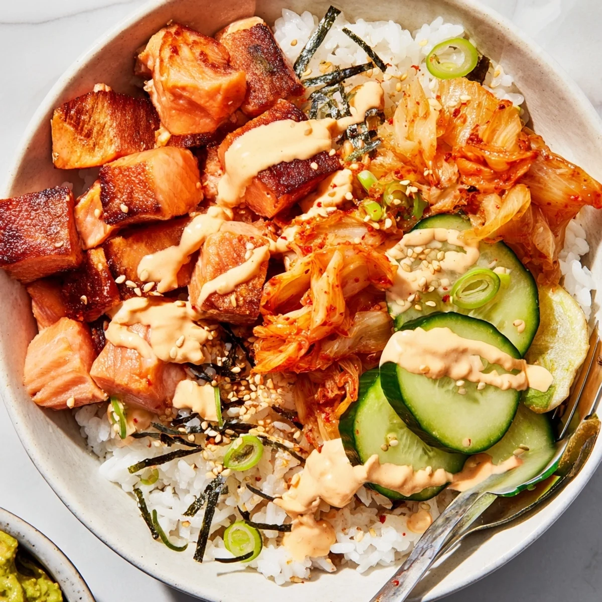 Enjoy a vibrant Crispy Salmon Rice Bowl with roasted nori and tangy kimchi.