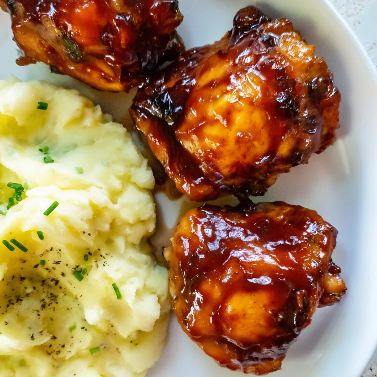 Tender Honey BBQ Chicken Thighs with a perfectly caramelized glaze and smooth, savory mashed potatoes.