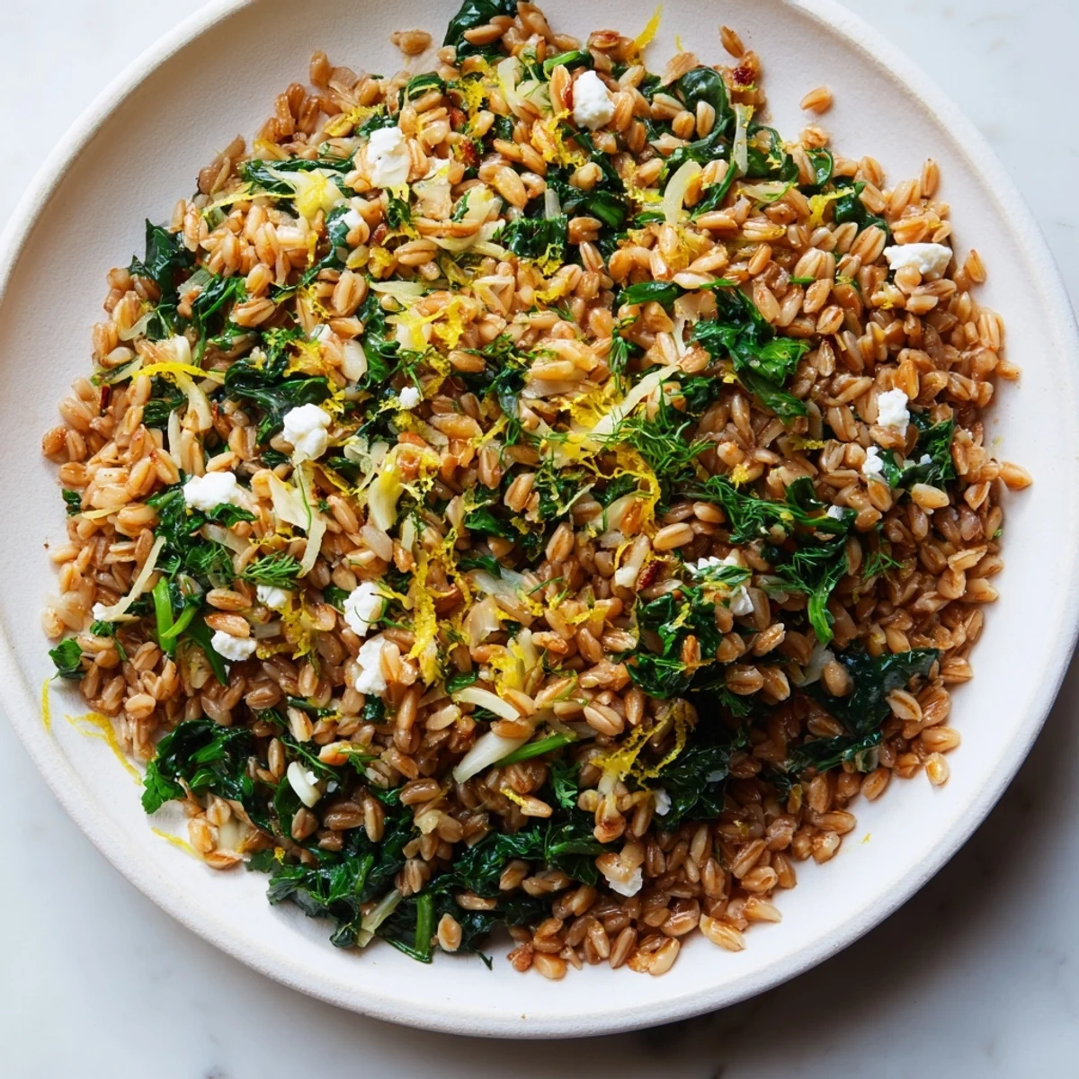 Golden-brown toasted almonds top this vibrant Warm Farro & Greens Pilaf, ready to enjoy.