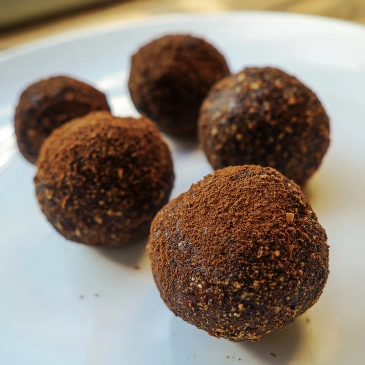 A close-up of Date & Walnut Truffles, dusted in cocoa, ready to enjoy as a sweet treat.