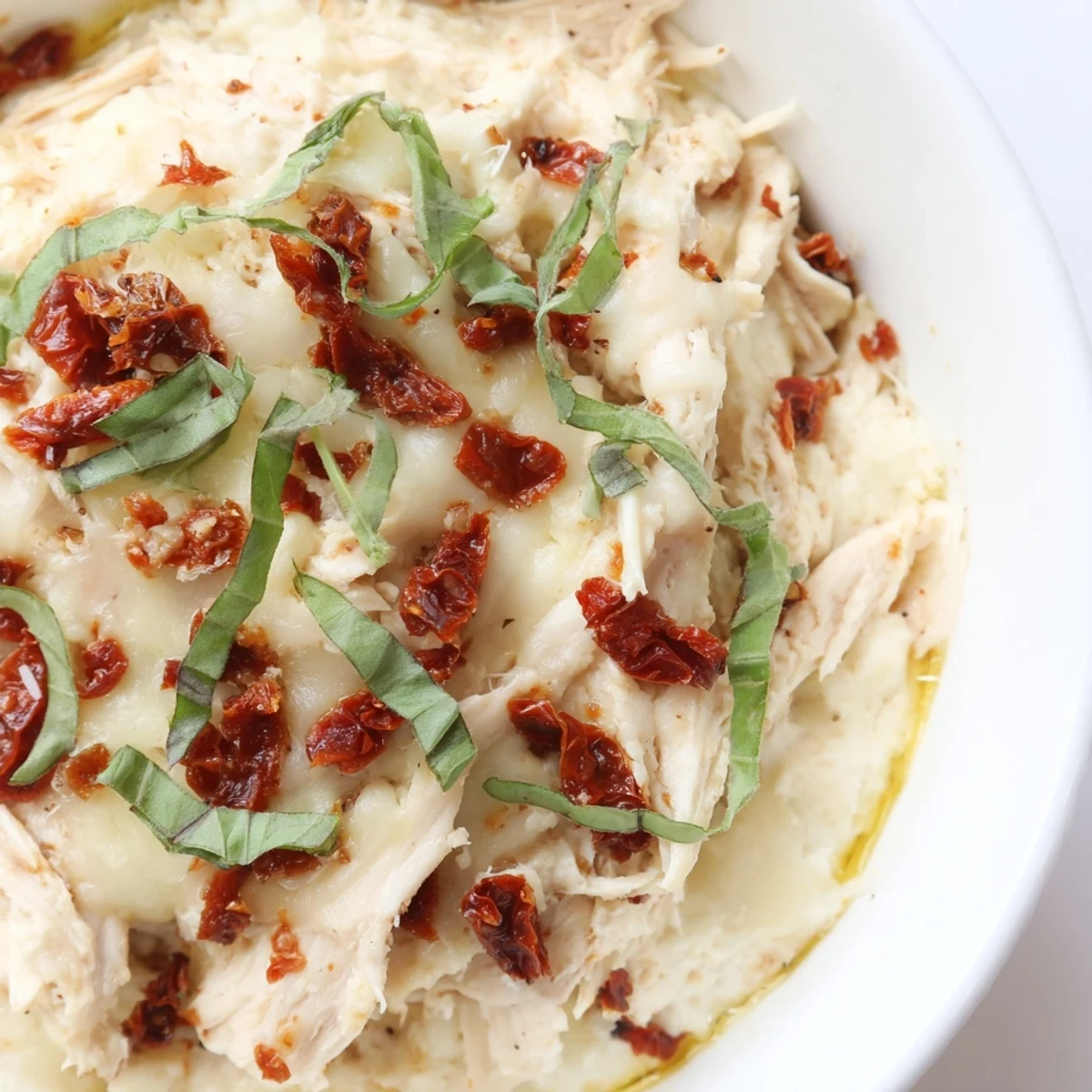 Golden, bubbly Lightened Marry Me Chicken Dip, speckled with sun-dried tomatoes, ready for scooping.