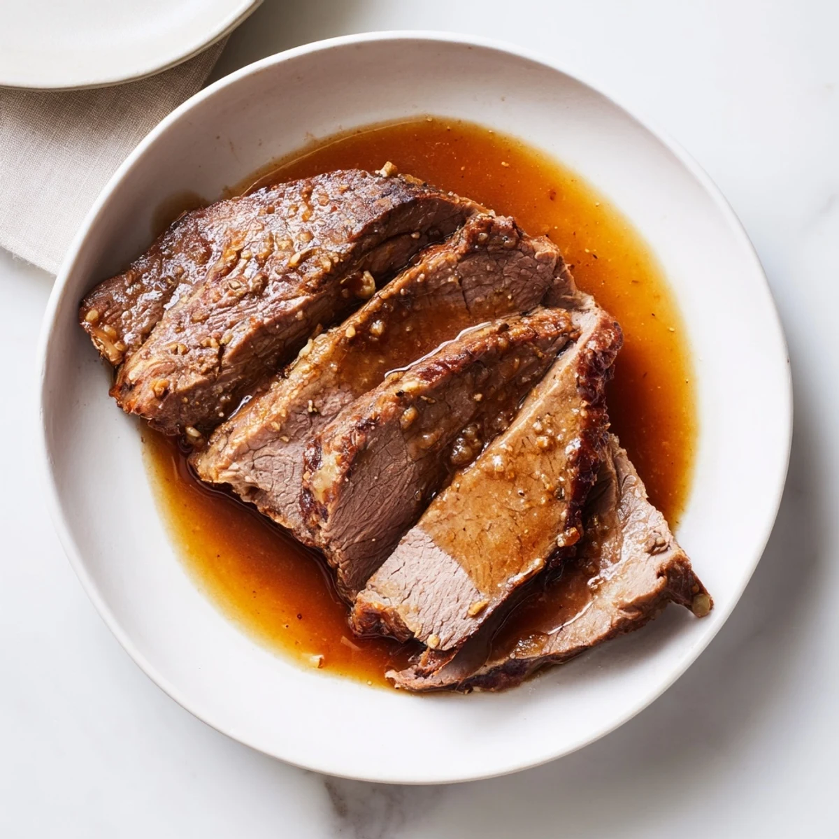 Tender Budget Holiday Chuck Roast, falling apart and ready to serve with rich, savory pan juices.