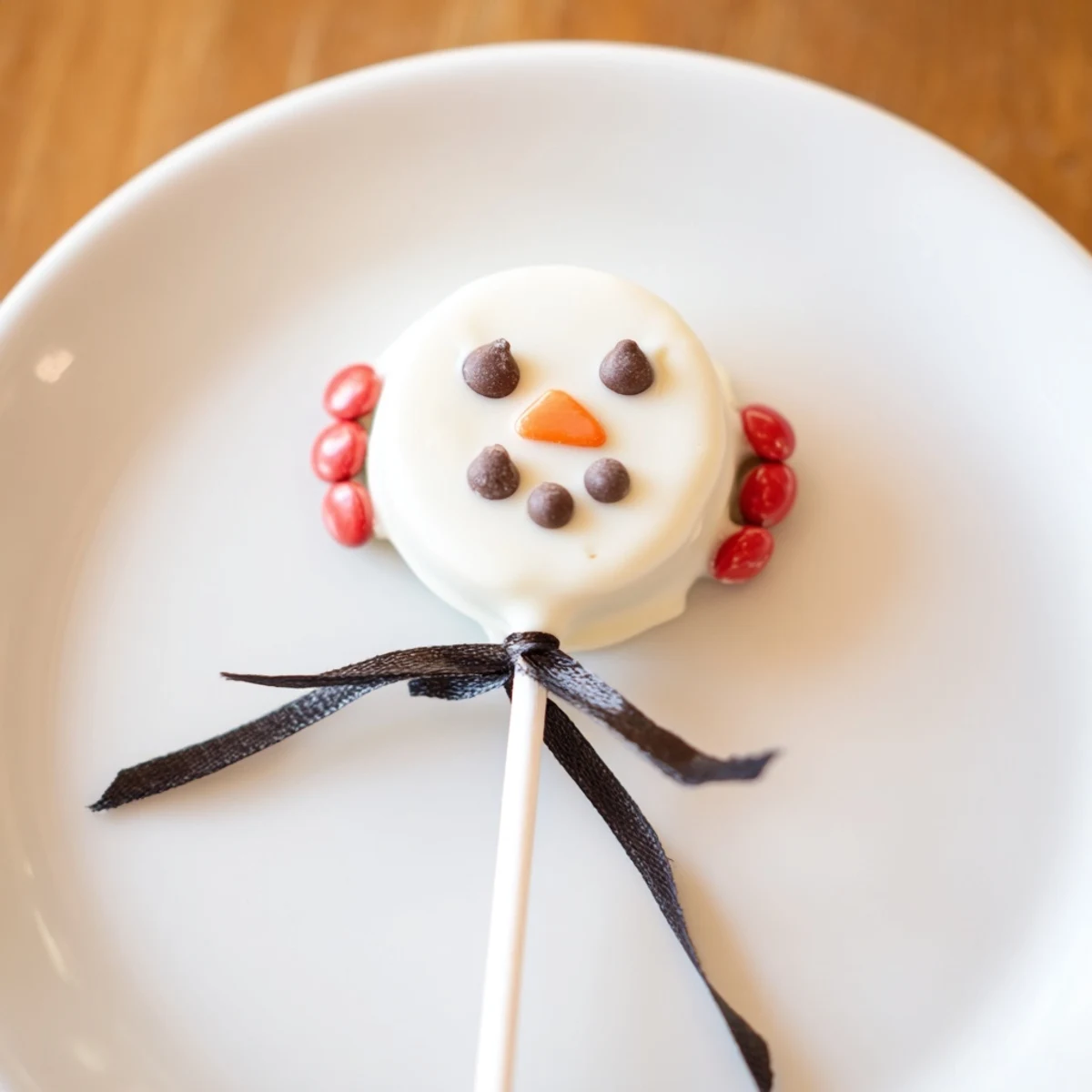 Adorable Budget-Friendly Oreo Snowman Pops: chocolate-covered cookies decorated exquisitely with festive details.