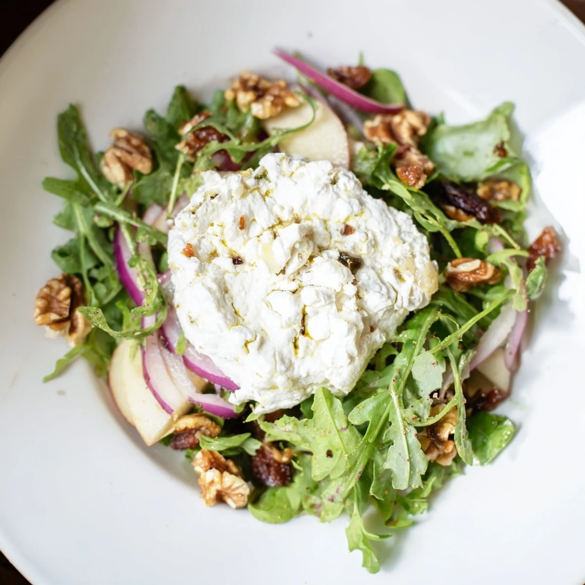 Creamy goat cheese and sweet dates star in this Spiced Honey and Date Goat Cheese Salad photo.