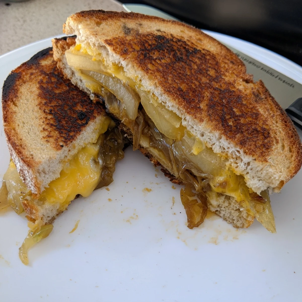 Golden, gooey Caramelized Onion, Apple & Cheddar Grilled Cheese, ready to be sliced and enjoyed.