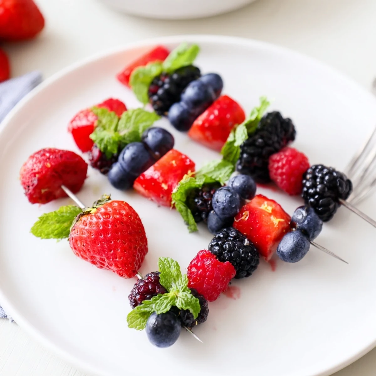 Vibrant red strawberries, plump blueberries and fresh mint make these easy fruit skewers, perfect snacks.