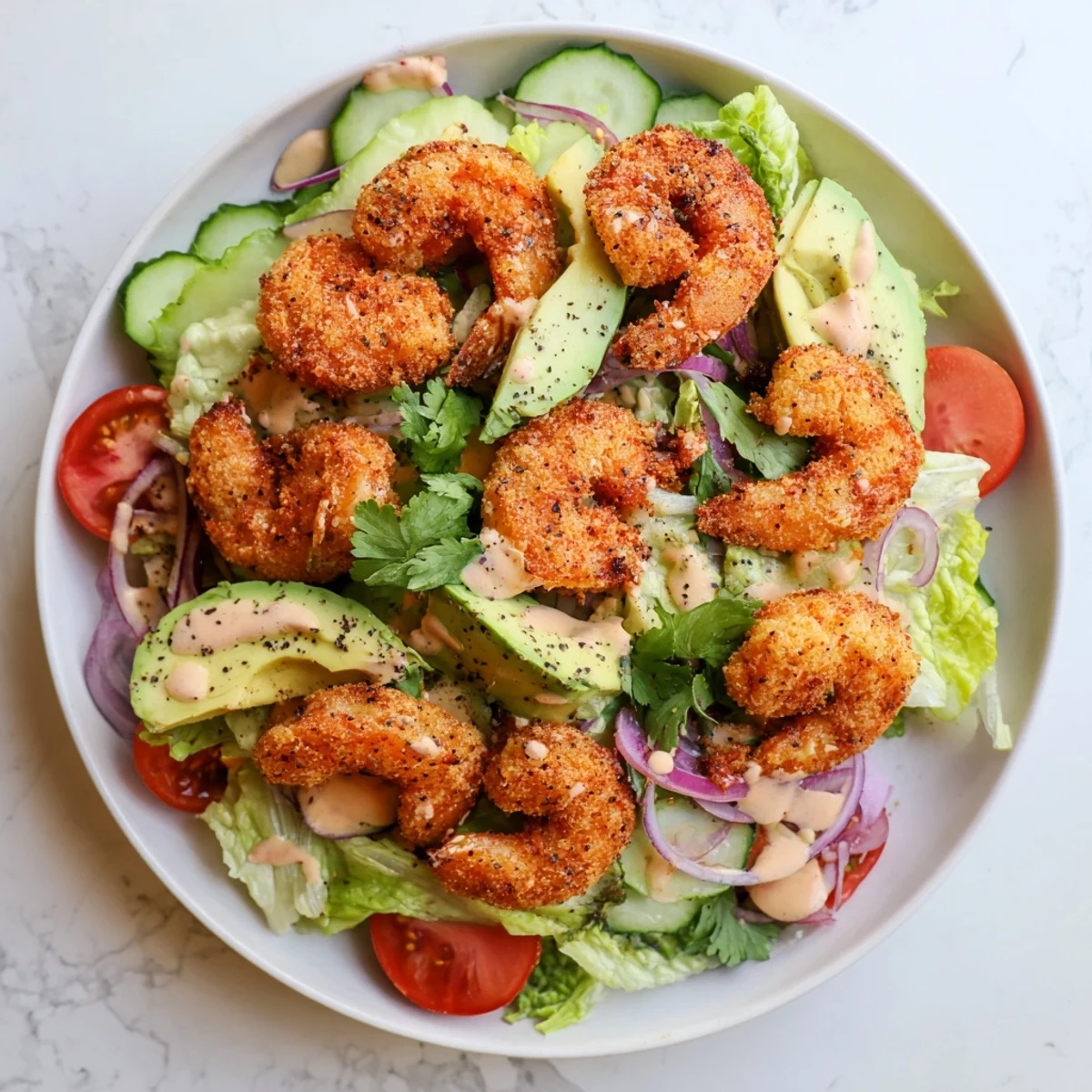 Golden crispy Spicy Crispy Shrimp Salad with avocado and a vibrant sriracha-lime dressing, ready to eat.