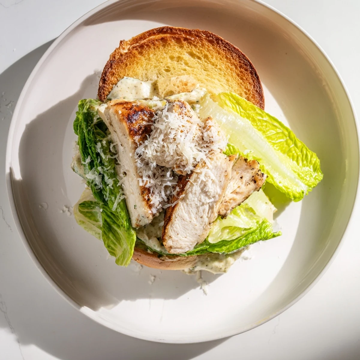 Golden Caesar Chicken Sandwich stacked high with juicy grilled chicken, crisp romaine, and creamy dressing on a toasted bun.  