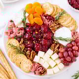 Festive Cranberry Wreath appetizer, visually striking with cheeses, grapes, and a glistening cranberry sauce center.