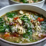 One-Pot Lemon Chicken Rice Soup with Veggies served in a white bowl, garnished with fresh parsley and lemon slices. 