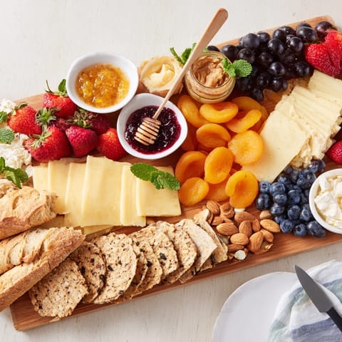Enticing jam-infused brunch board with creamy brie, fruits, and crusty breads.  