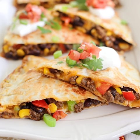 Crispy sheet pan quesadillas with beef, cheese, and vibrant veggies, perfect for sharing.  