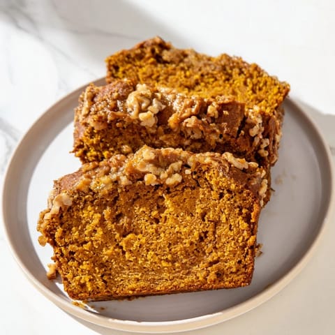 A slice of golden pumpkin bread, delicious with nuts, perfect for breakfast or dessert with a coffee.