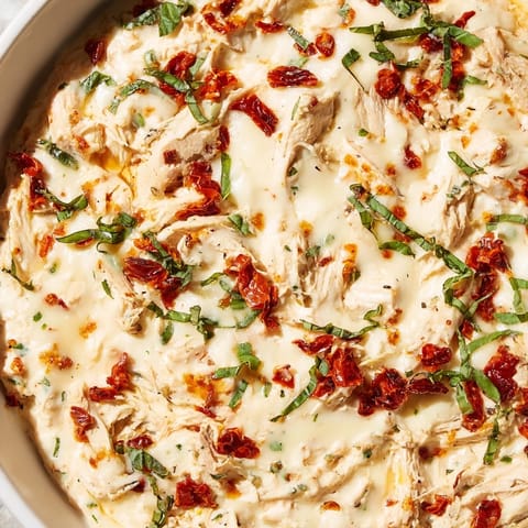 Creamy and savory, this warm Lightened Marry Me Chicken Dip is served with fresh herbs and crackers.