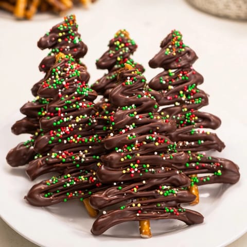 Melted chocolate drizzled into festive Express Chocolate Christmas Trees, ready for sprinkles and enjoyment.