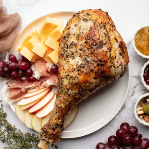 A close-up of a Thanksgiving Turkey Legs Charcuterie board, brimming with savory meats and festive sides.
