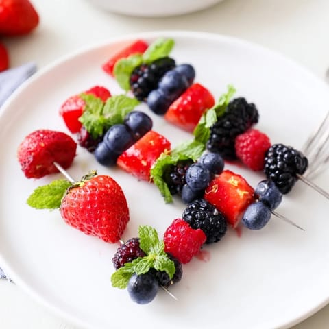Vibrant red strawberries, plump blueberries and fresh mint make these easy fruit skewers, perfect snacks.