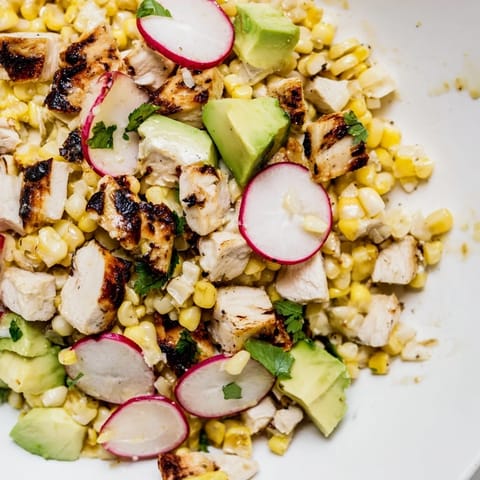 Hearty Roasted Corn & Chicken Chopped Salad tossed with crisp romaine, radishes, and a zesty lime dressing.  