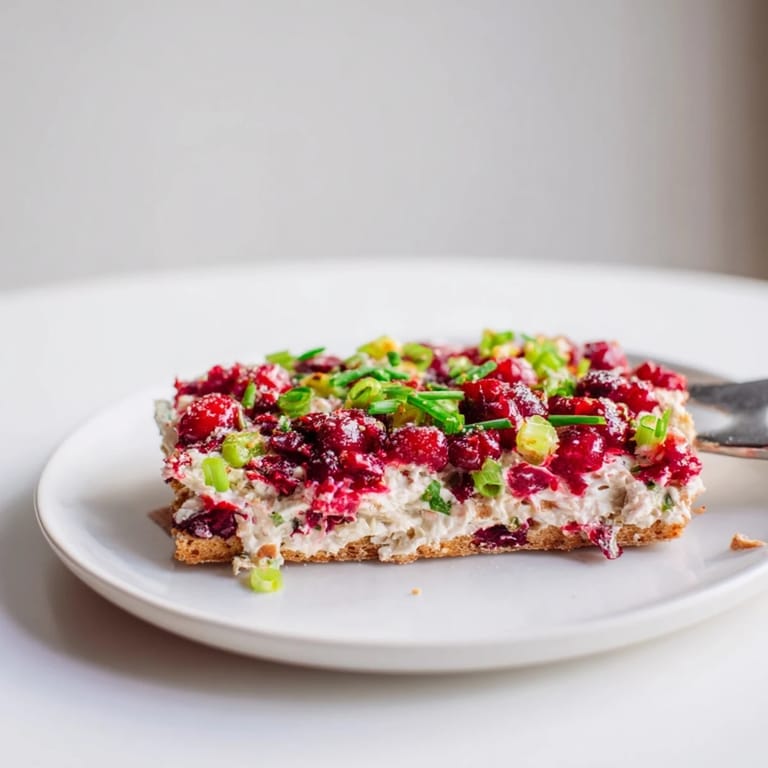 Creamy Spicy Ginger Cranberry Jalapeño Dip spread on crackers, bursting with flavor and zest.