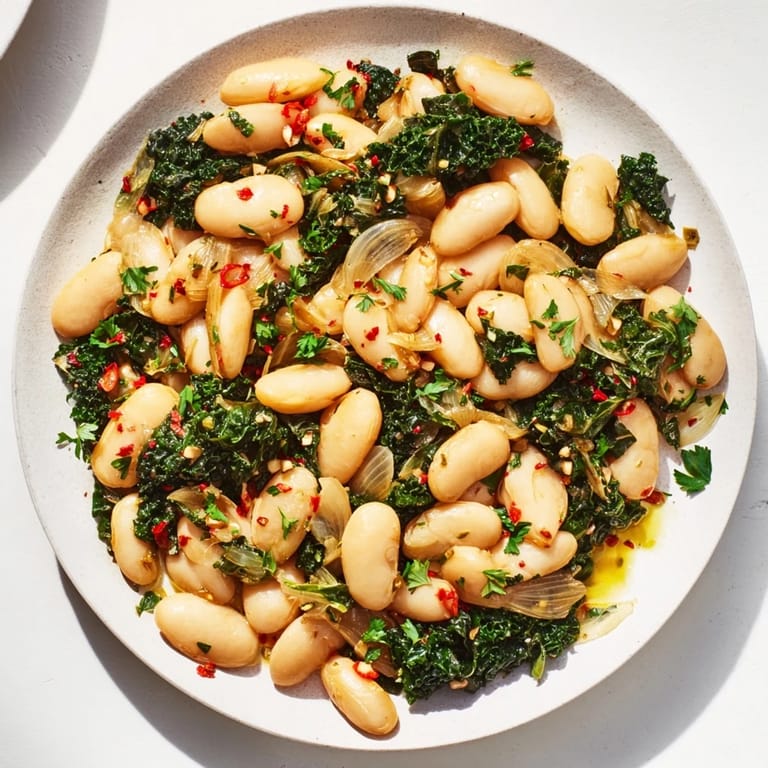 Rustic Garlicky Beans with Winter Greens, a delicious vegan dish served in a warm bowl with fresh parsley.