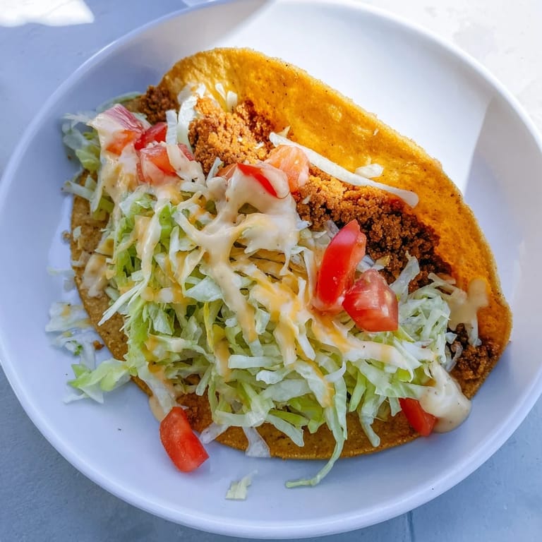 A close-up shot of a perfect Cheesy Gordita Crunch taco, filled with seasoned beef and fresh toppings.