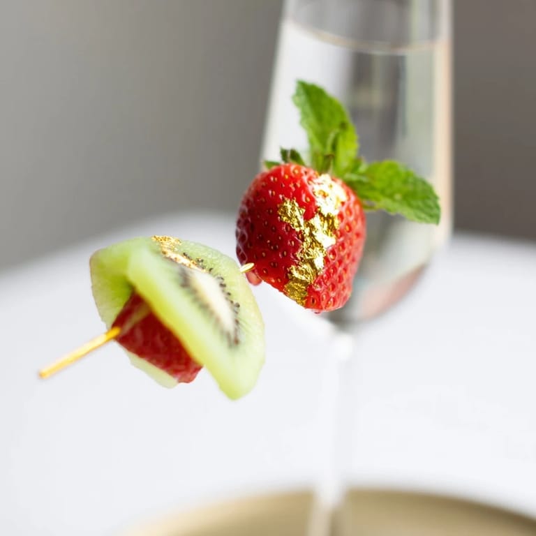 These elegant champagne flute fruit garnishes showcase sliced kiwi, lime, and berries perfect for 2026 celebrations.