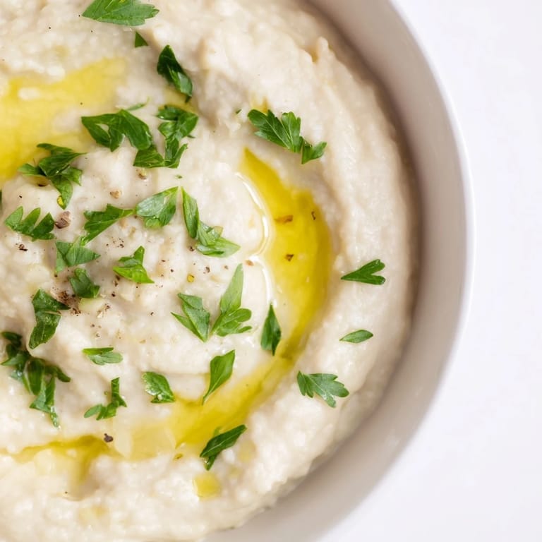 Fresh and flavorful White Bean Dip, garnished with parsley, perfect as a party appetizer.